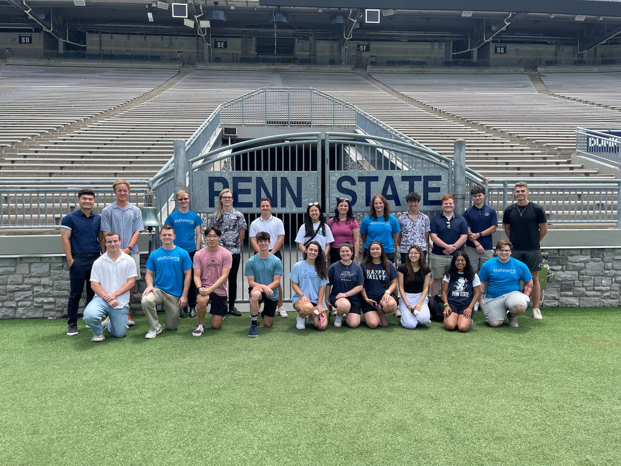 Praktikanten bei Minitab stehen vor dem Tor zum Penn State Beaver Stadium